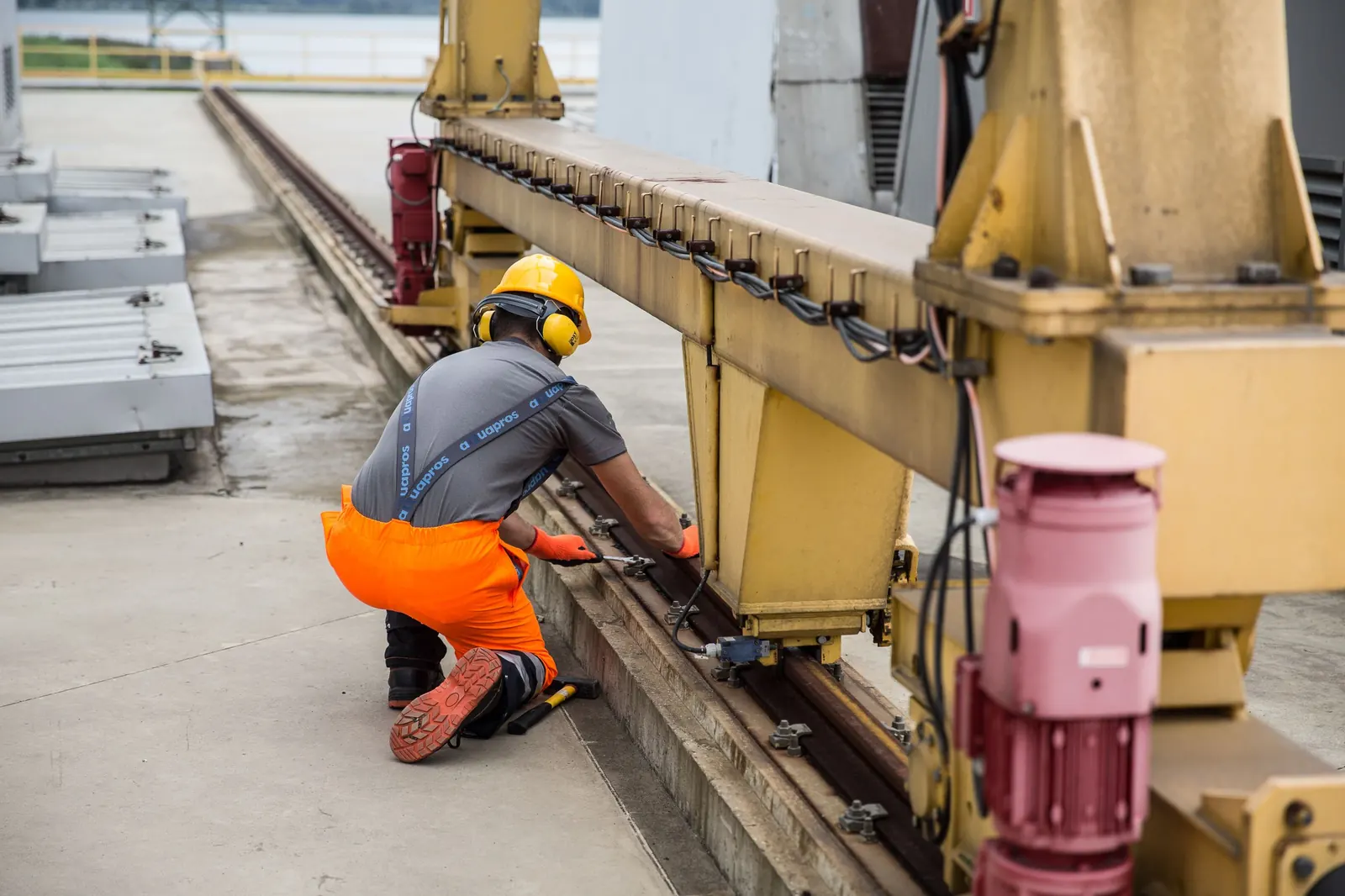 Técnico de capacete inspeciona um equipamento industrial de grande porte